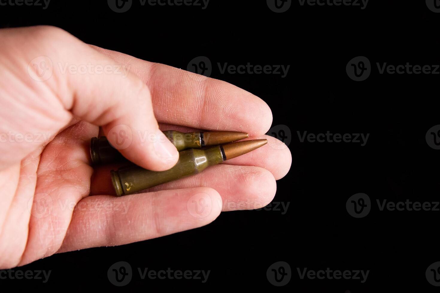kogels in een hand, hand- Holding een kogel Aan zwart achtergrond foto