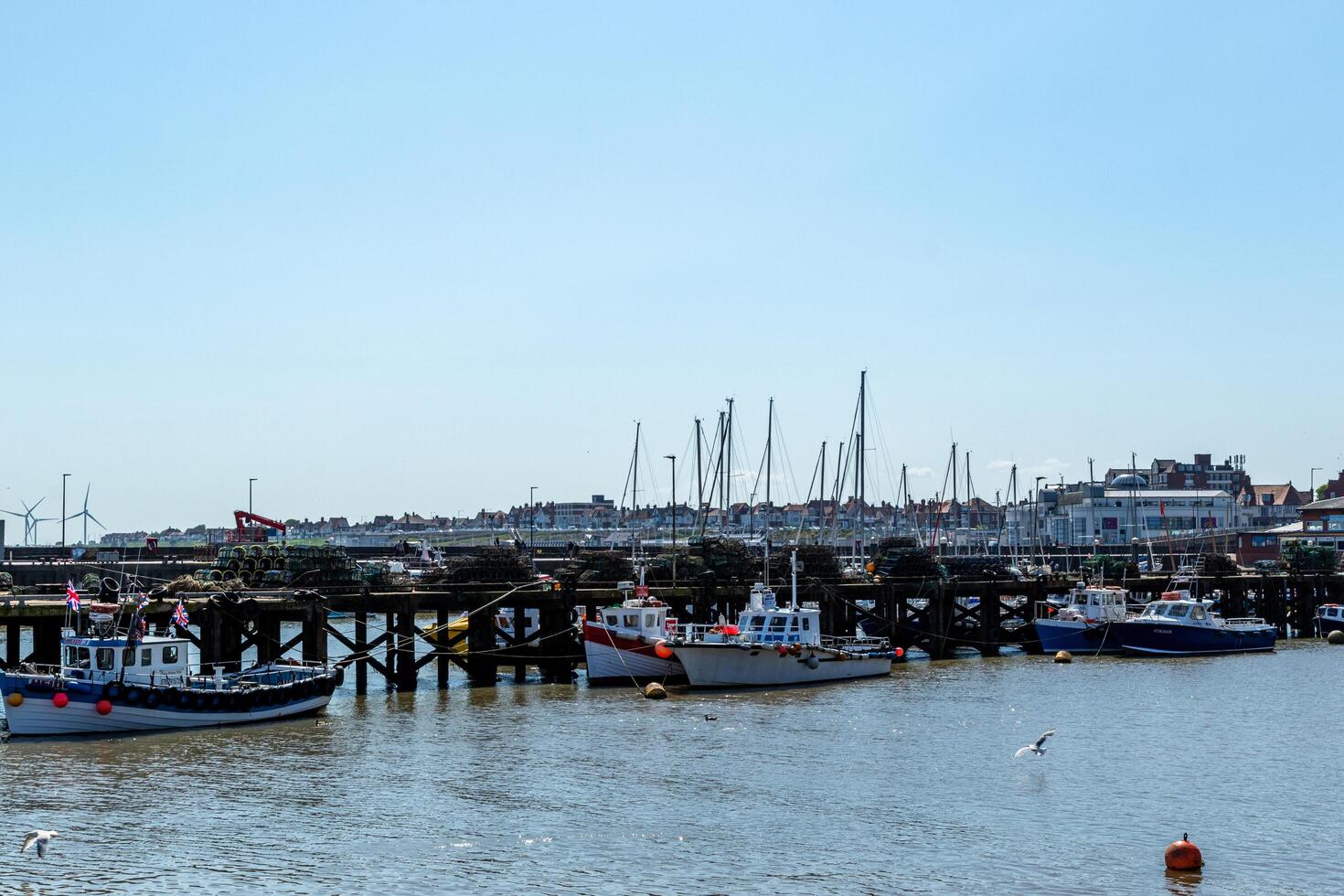 toneel- visie van een haven met boten en een pier tegen een Doorzichtig blauw lucht in Bridlington, Engeland. foto