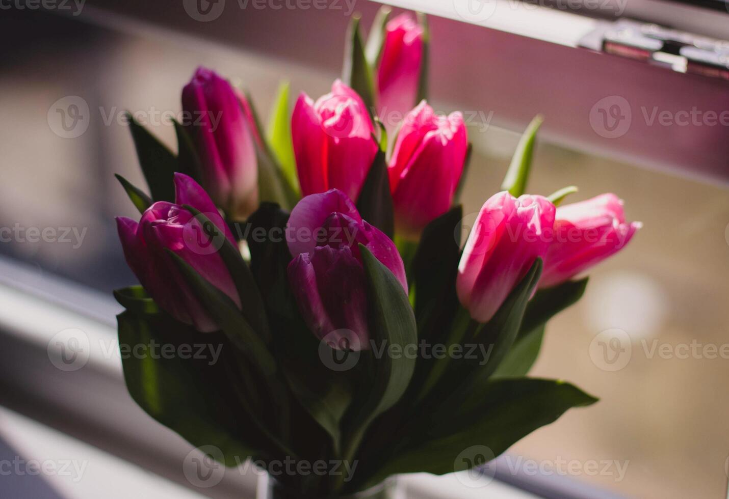 boeket van roze tulpen in een vaas Aan de vensterbank foto