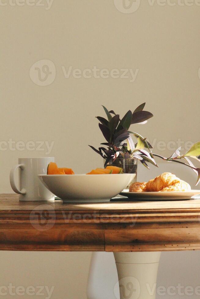 ontbijt met koffie, croissant en fruit Aan de tafel foto