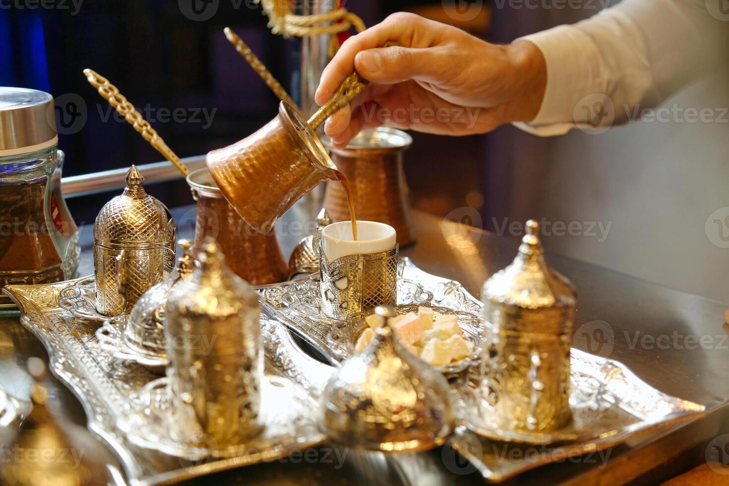 persoon gieten thee in kop met theepot en keramisch serviesgoed foto