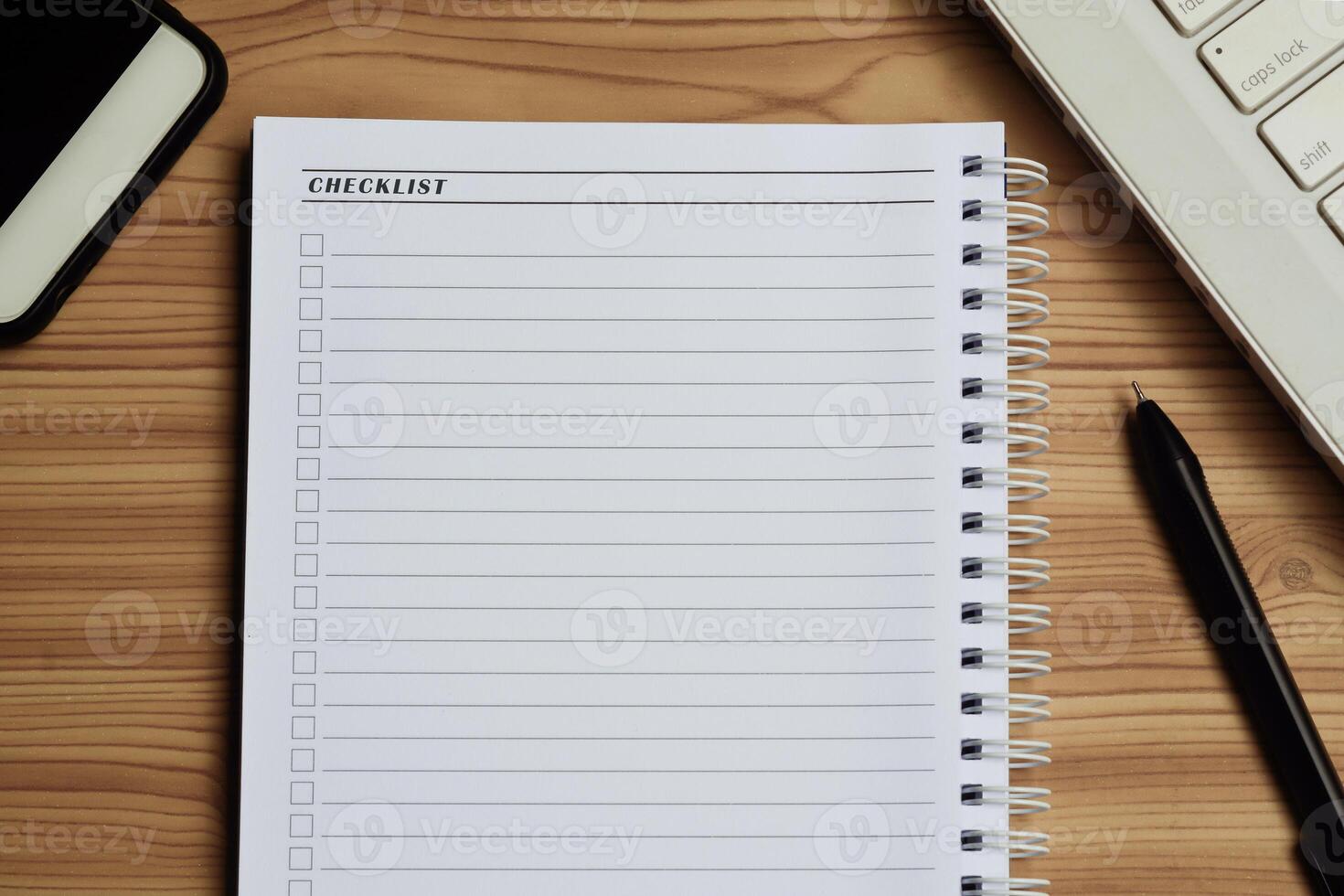 blanco checklist met ruimte voor teken Aan kladblok met laptop, smartphone en pen. foto