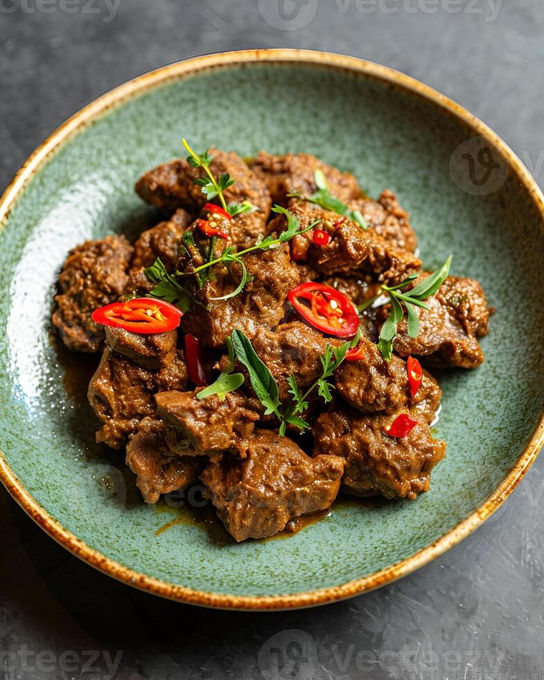 ai gegenereerd rendang met gesneden pepers Aan een licht groen bord Aan een grijs tafel achtergrond foto