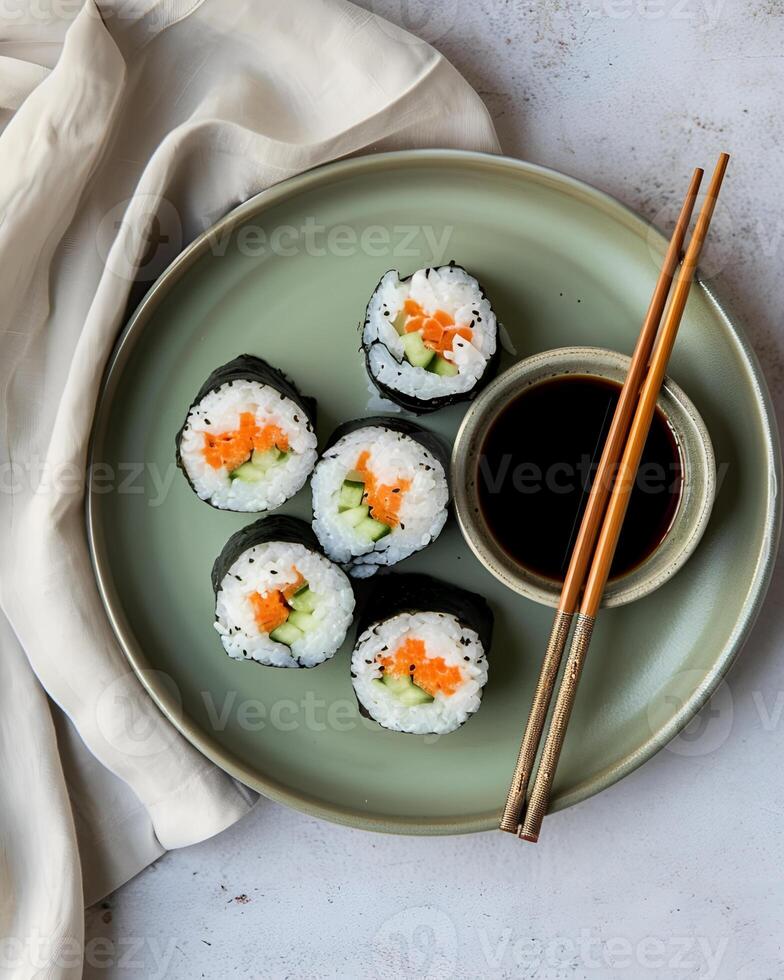 ai gegenereerd futomaki sushi Aan een groen bord met shoyuu in een klein schaal, Daar zijn twee eetstokjes en een lap, de tafel gebruikt is helder cement foto