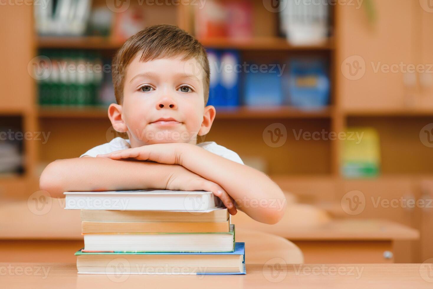 onderwijs en school- concept - glimlachen weinig jongen met veel boeken Bij school- foto
