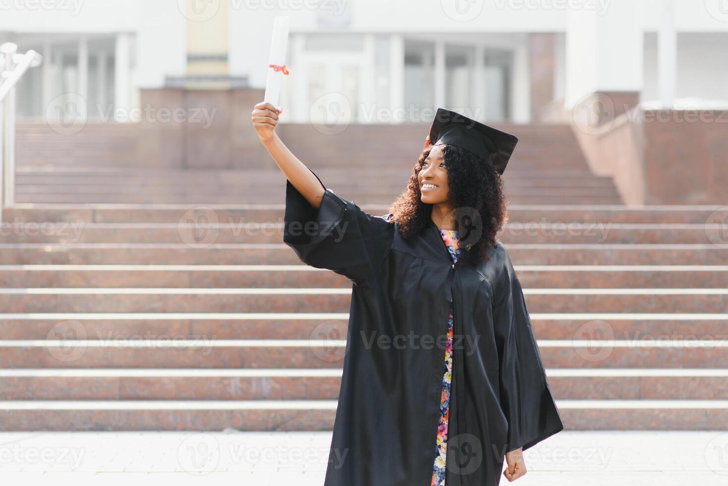 vrolijke Afro-Amerikaanse afgestudeerde student met diploma in haar hand foto