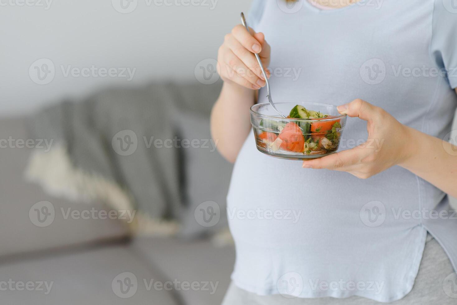 mooi gezond zwanger vrouw aan het eten groente salade foto