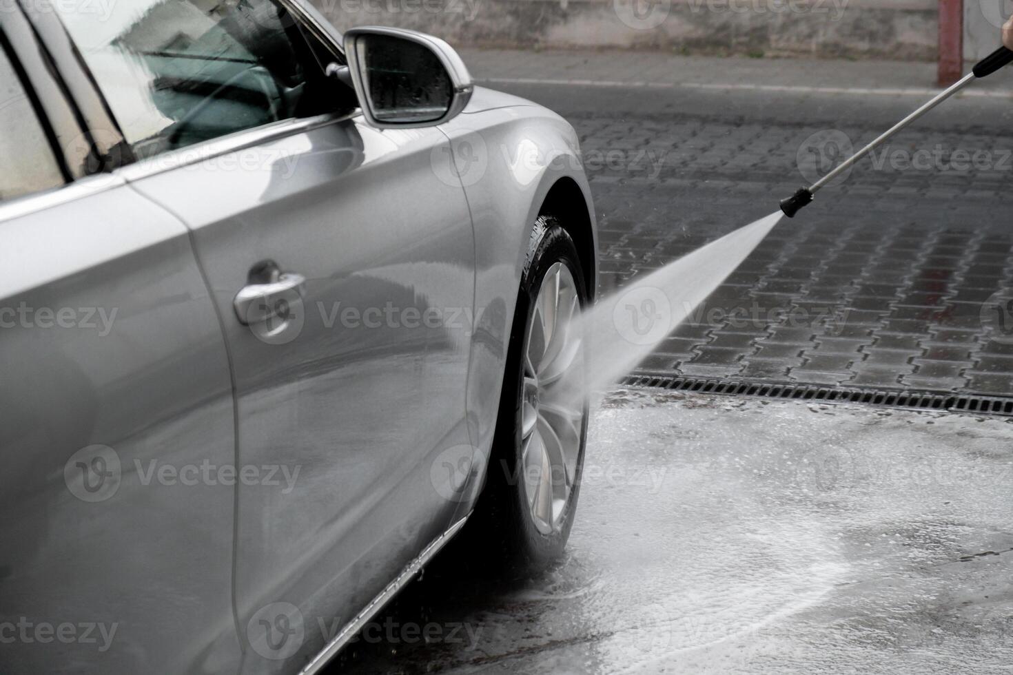 het wassen luxe zilver auto Aan contactloos auto wassen. het wassen sedan auto met schuim Zelfbediening en hoog druk water. schoonmaak de details van auto. netheid en bestellen in stedelijk milieu foto