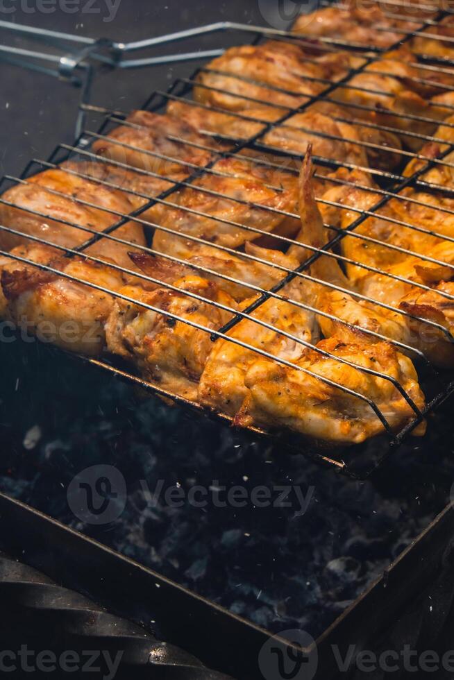 bbq picknick tijd geroosterd kip poten en Vleugels Aan grillen. grillen vlees Aan buitenshuis rooster rooster smakelijk barbecue kip steak met rook vlammen sappig vlees in de achtertuin in zomer foto