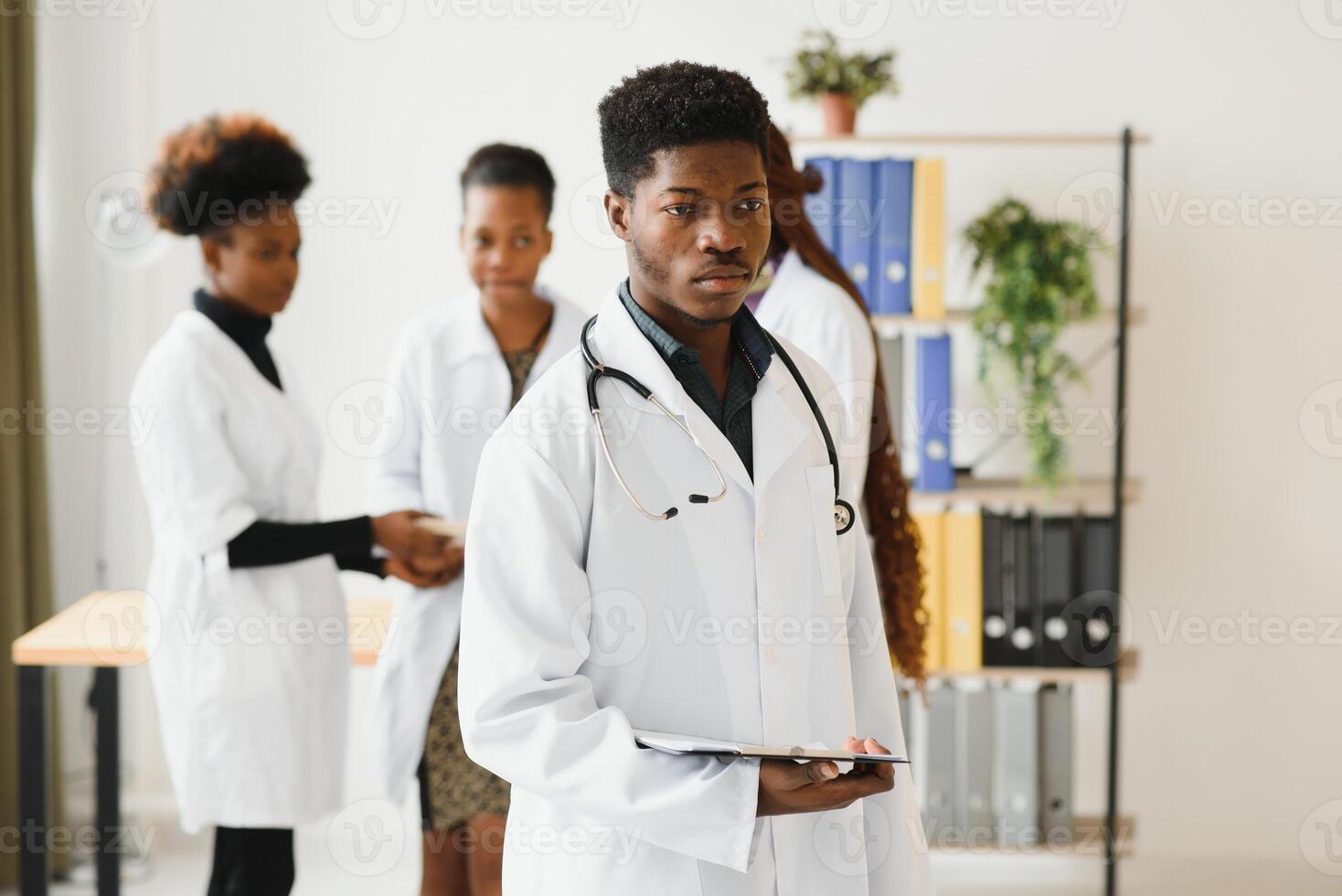 portret van een Afrikaanse dokter in voorkant van zijn medisch team. foto