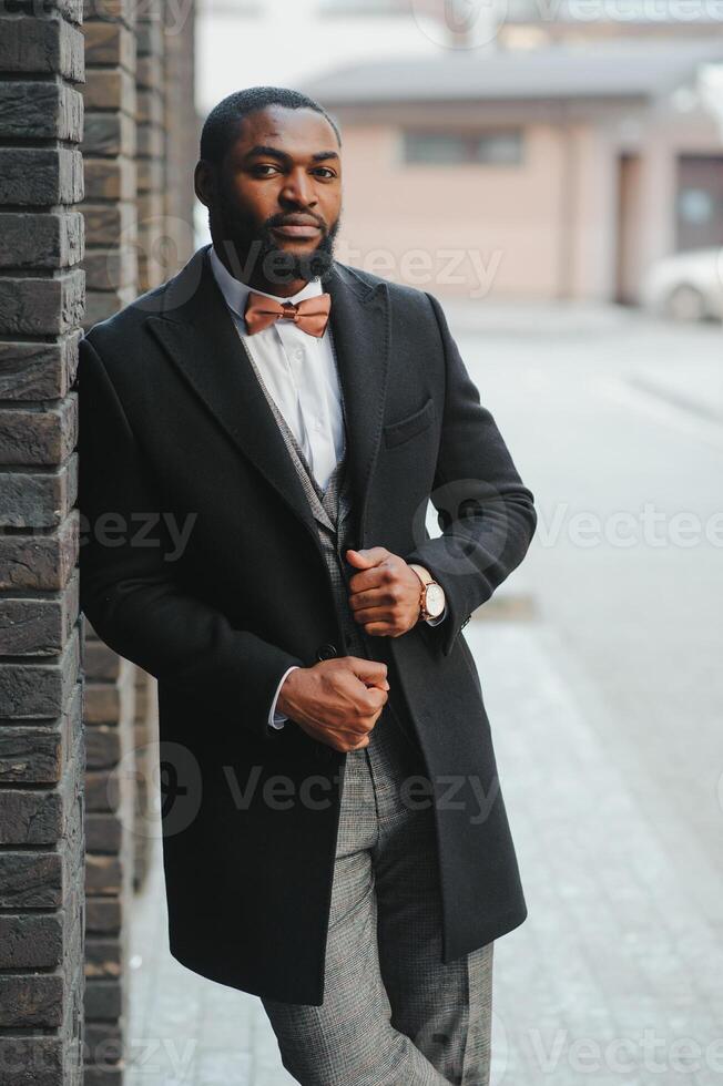 mode portret van een knap jong Afrikaanse Amerikaans bedrijf Mens wandelen buitenshuis in een gewoontjes houding. foto