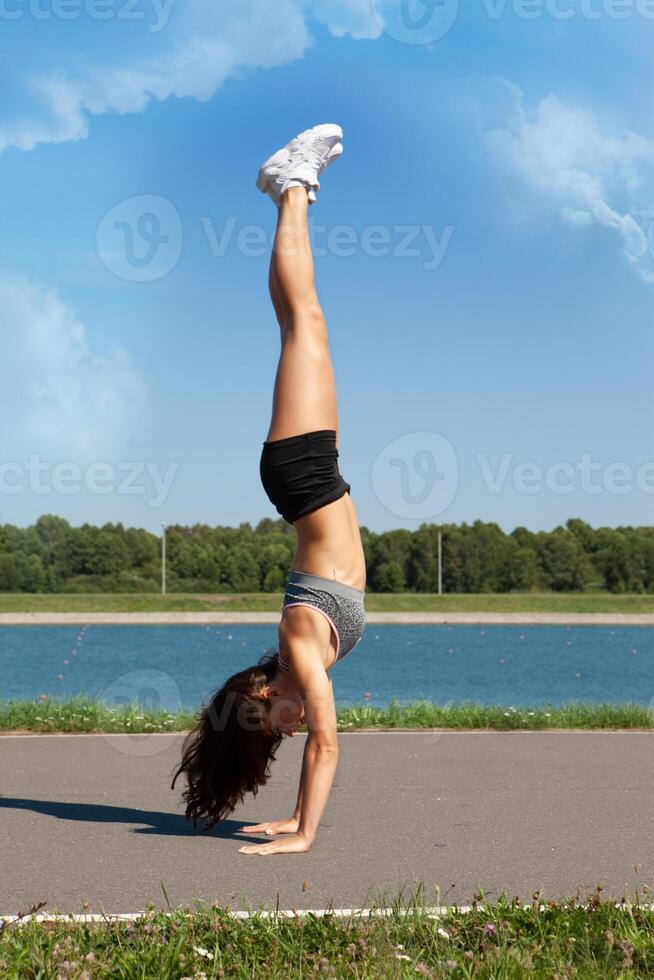 jong sport- meisje aan het doen yoga hoofd naar beneden foto