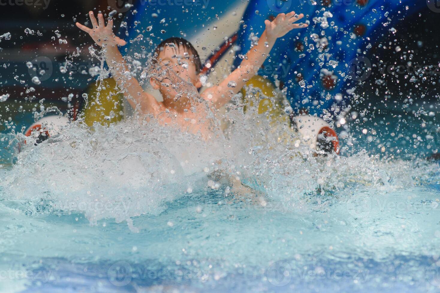 de jongen is rollend met een water glijbaan Bij een water park in weinig rots foto