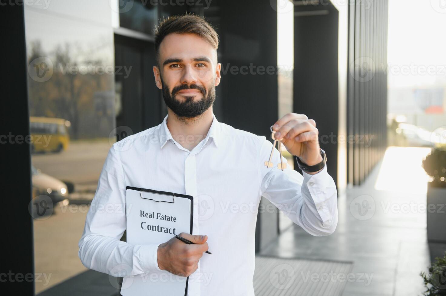 mannetje makelaar staand buiten woon- eigendom Holding sleutels foto