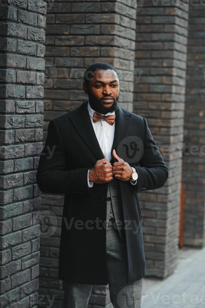 portret van een Afro-Amerikaanse zakenman die een pak draagt dat zich in een openlucht bedrijfsomgeving bevindt foto