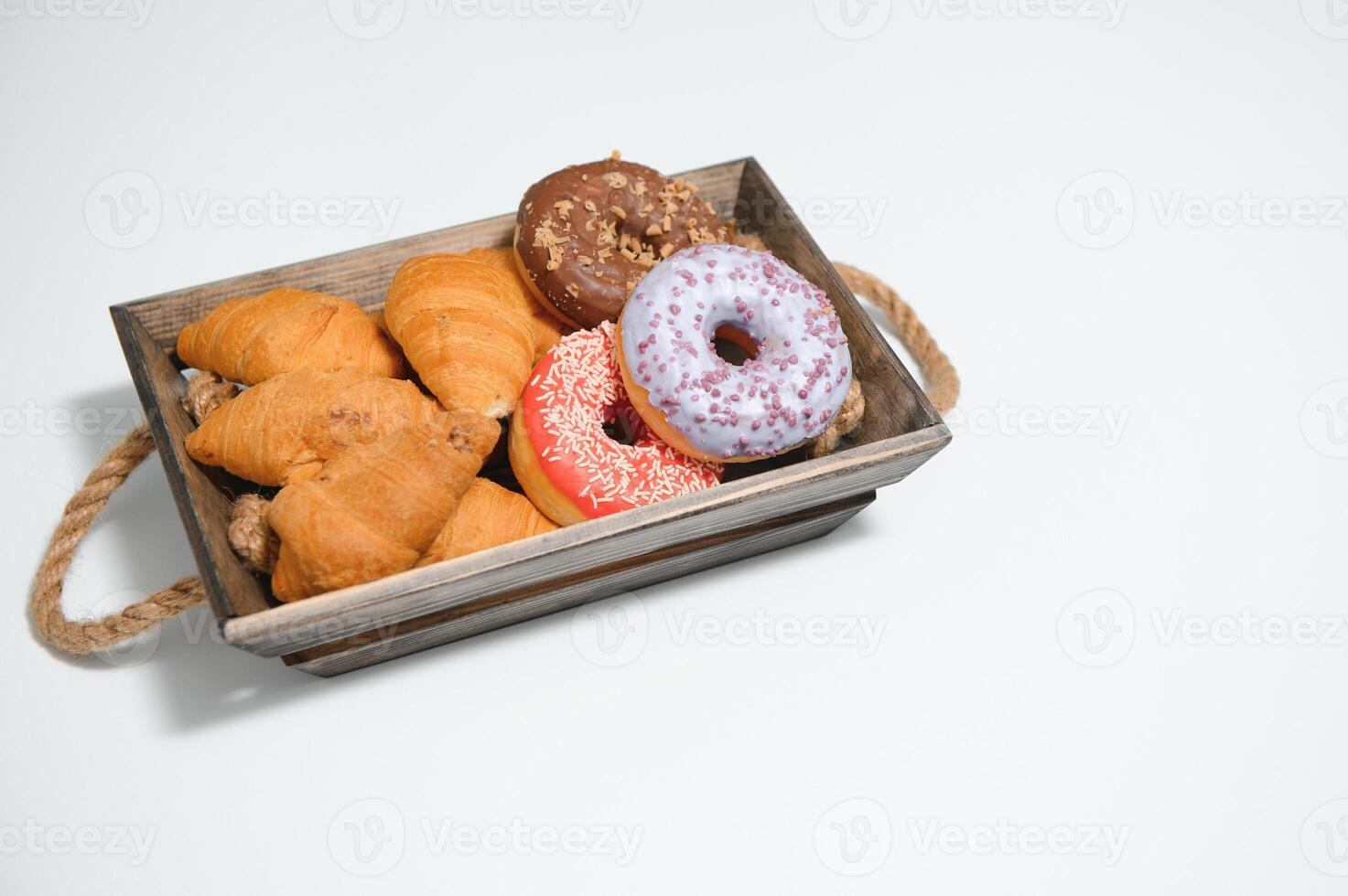 een kraft doos met brood producten, donuts, croissants in de keuken foto