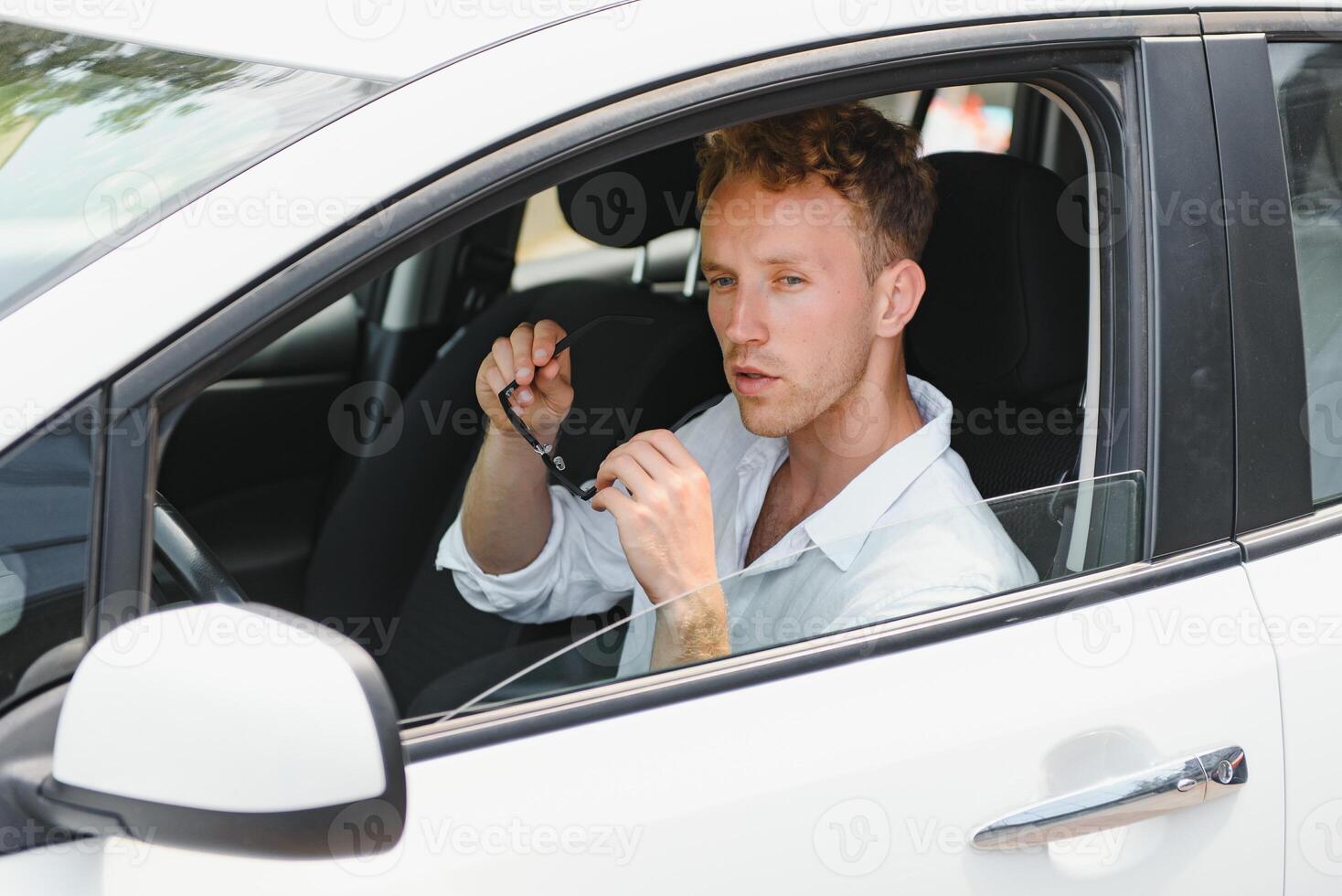 elektrisch auto bestuurder - groen energie biobrandstof concept. mannetje achter wiel. Mens het rijden nieuw milieuvriendelijk voertuig jong mannetje eigenaar trots zelfverzekerd op zoek Bij camera, taxi bestuurder concept. foto