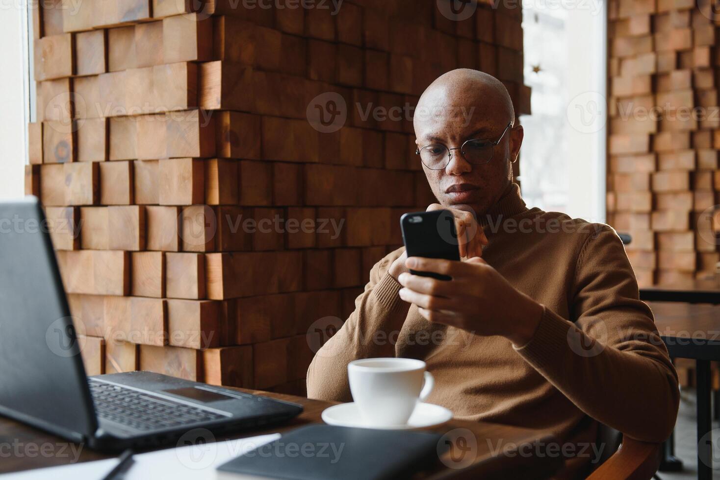 gefocust Afrikaanse Mens vervelend hoofdtelefoons aan het kijken webinar opleiding maken aantekeningen studie online aan het leren taal Aan computer, zwart mannetje leerling op zoek Bij laptop elearning in internet schrijven informatie. foto