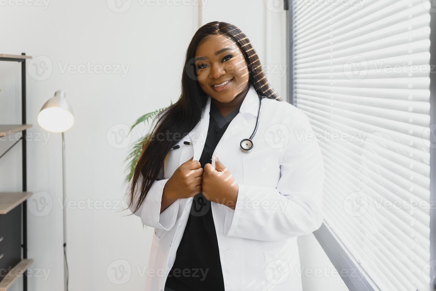 een Afrikaanse Amerikaans vrouw medisch dokter met een stethoscoop in ziekenhuis. foto