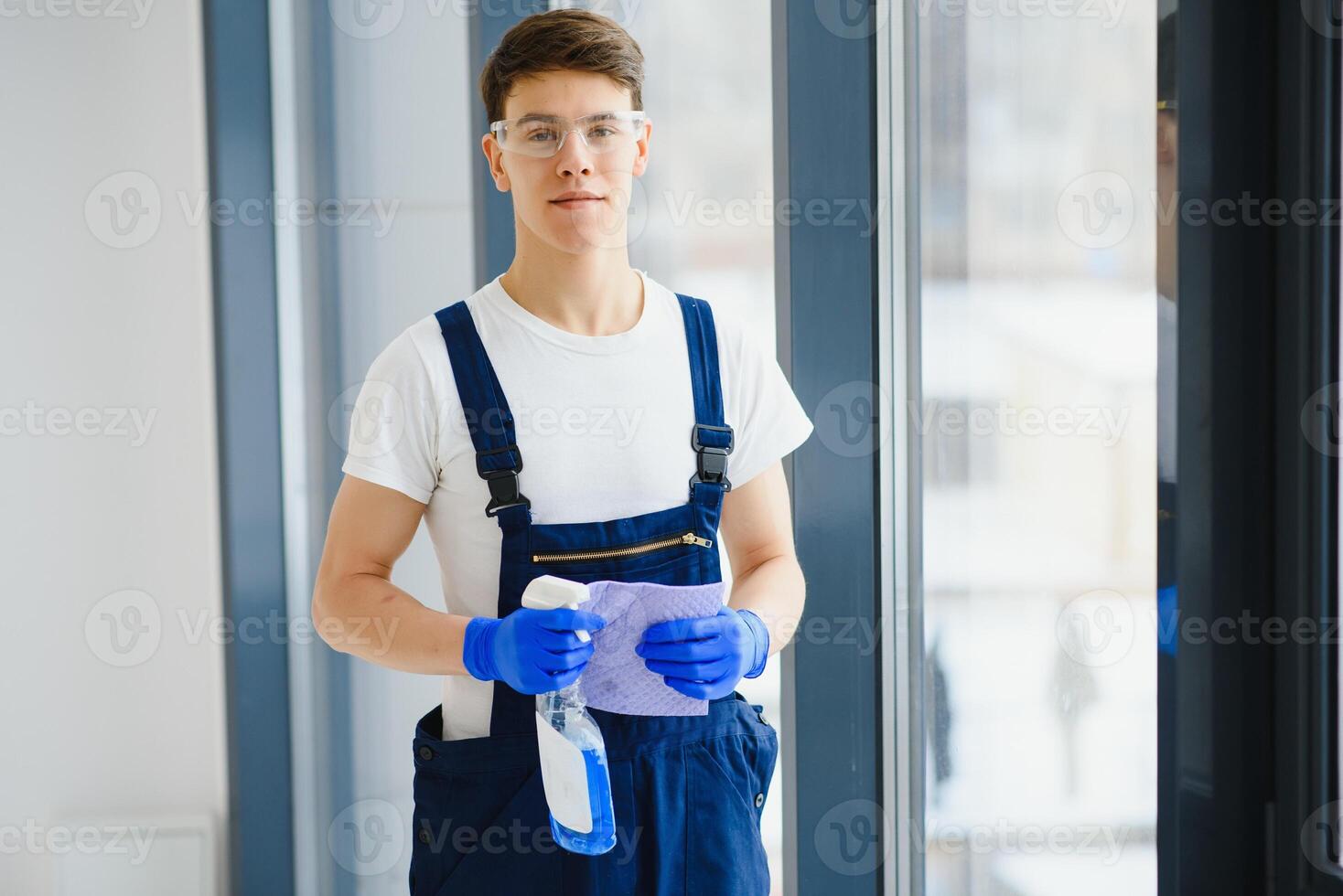 klusjesman schoonmaak de venster en glimlachen in een nieuw huis foto