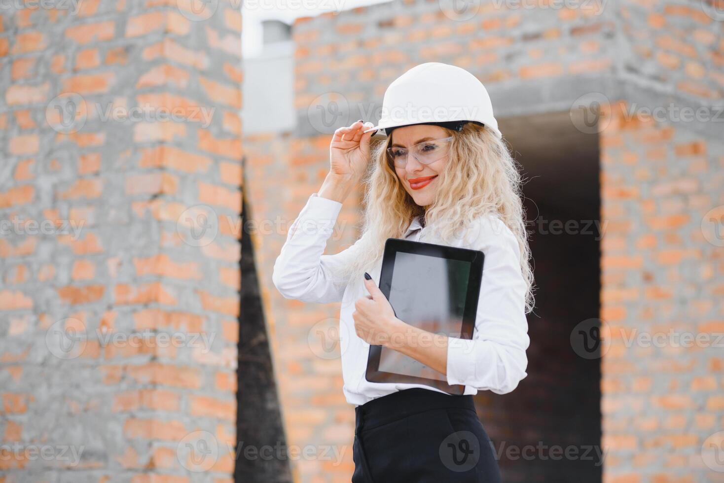 bouw ingenieur. meisje met bouw documentatie. een vrouw in een wit moeilijk hoed tegen de dak van een gebouw. bouw van een nieuw huis foto