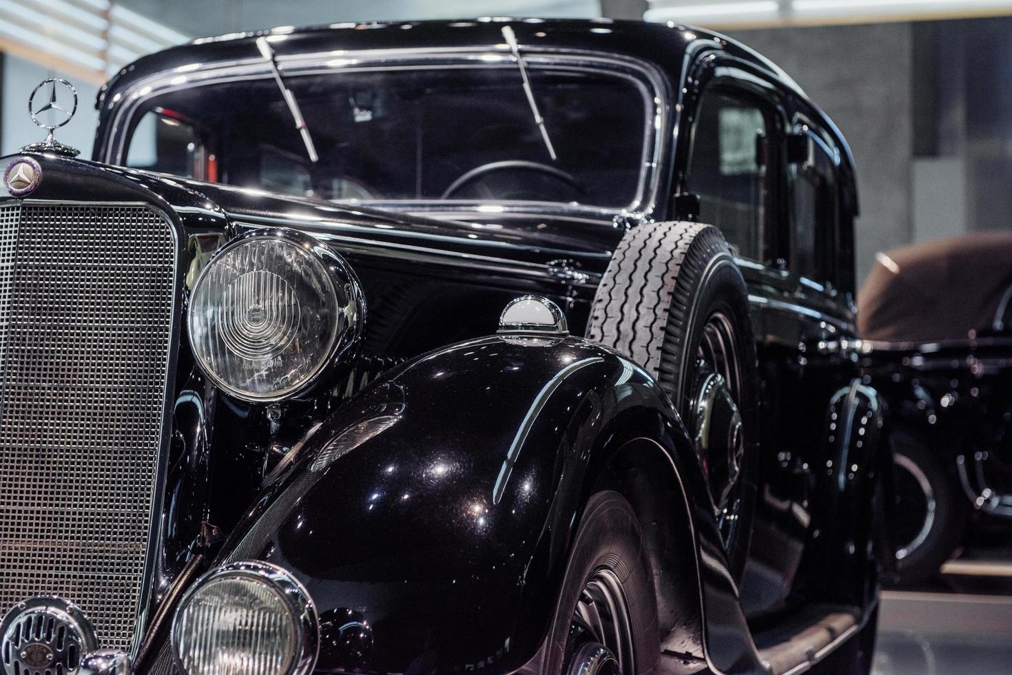 stuttgart, duitsland - 16 oktober 2018 mercedes museum. gepolijste zwarte retro auto met reservewiel aan de zijkant binnen geparkeerd foto