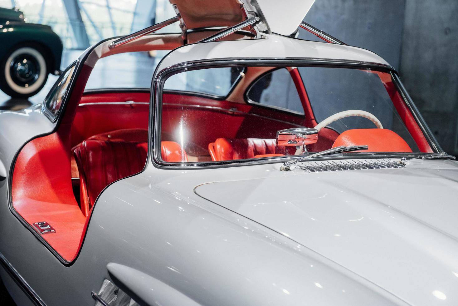 witte retro auto met autosalon en geopende deuren die op de autoshow staan foto