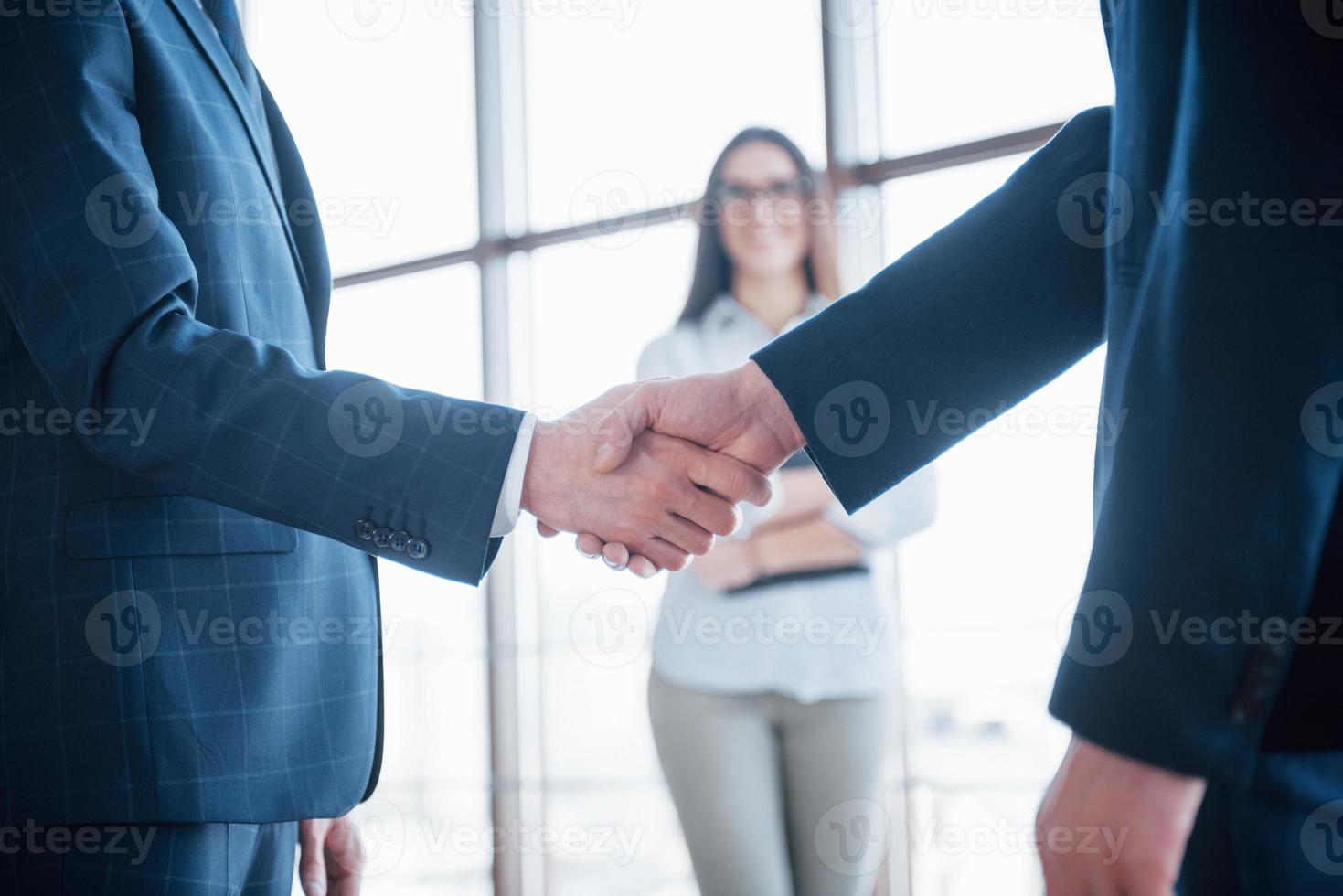 twee zelfverzekerde zakenman die handen schudt tijdens een vergadering op kantoor, begroeting en partnerconcept foto