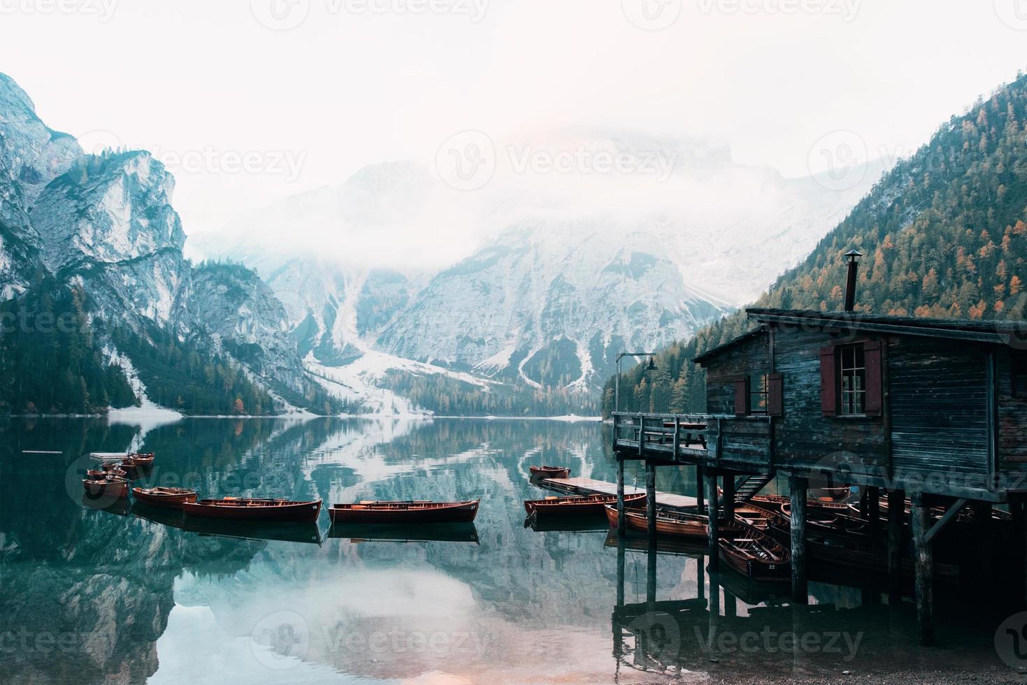 onderling verbonden boten zijn verbonden. goed landschap met bergen. toeristische plaats met houten gebouw en peer foto