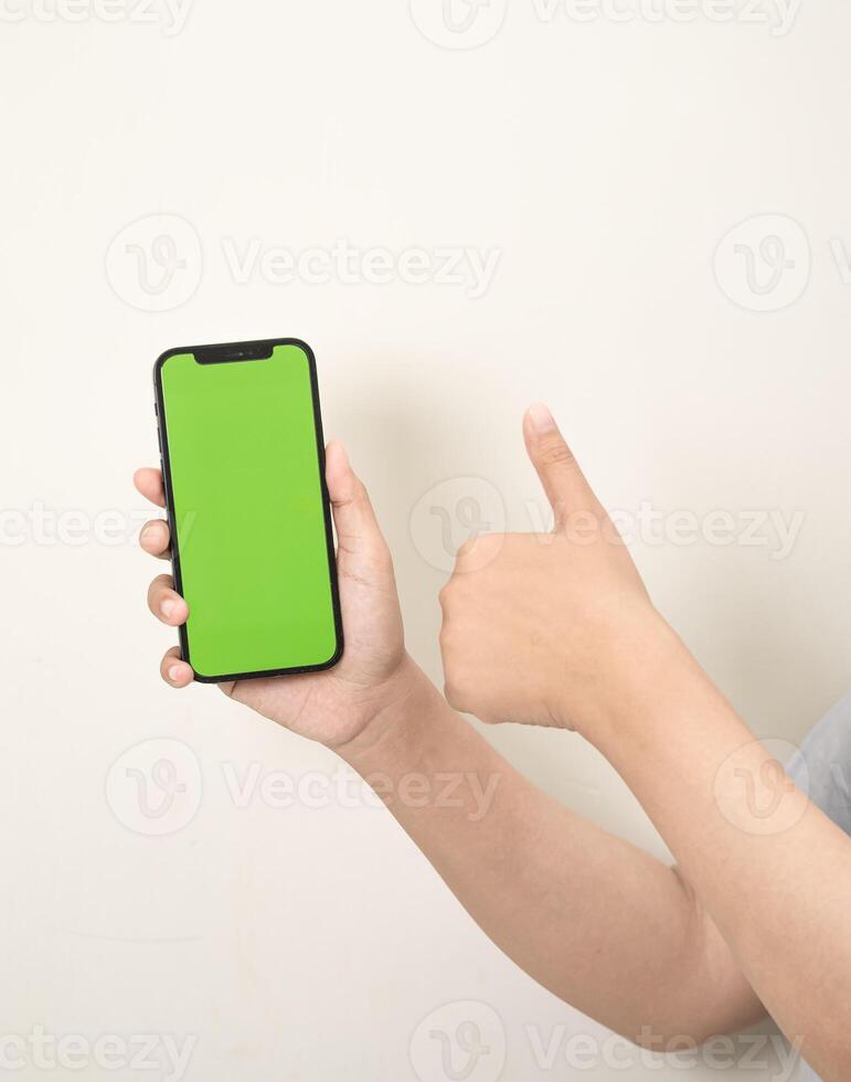 hand- is Holding een telefoon met groen scherm Aan een wit geïsoleerd achtergrond foto