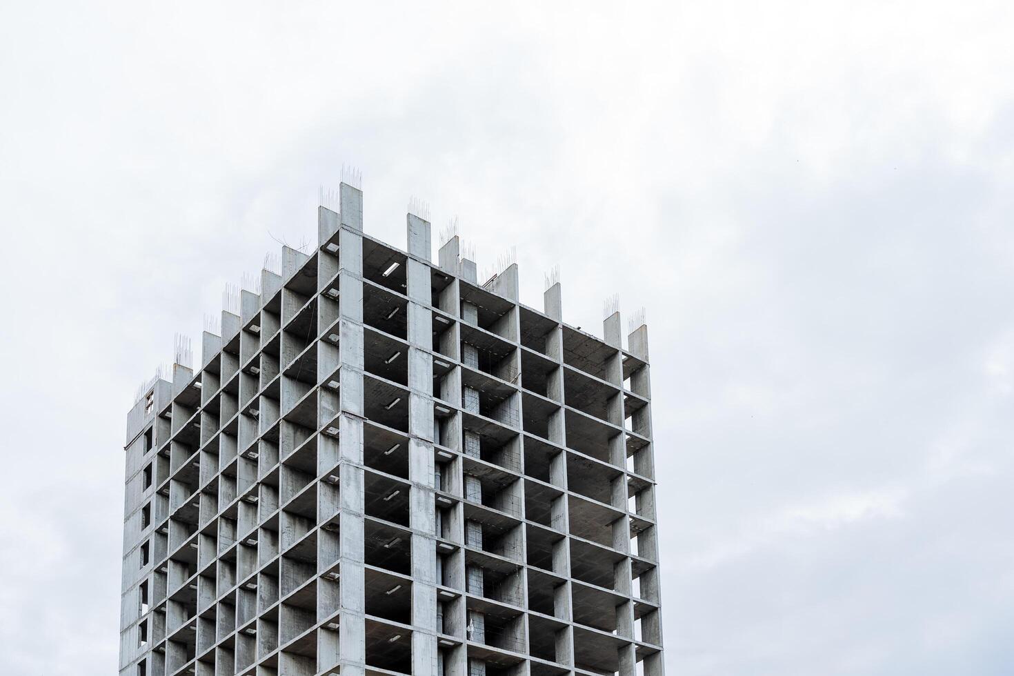 monolithisch beton gebouw tegen de lucht, bouw plaats van een appartement gebouw, beton muren van grijs kleur, chinastad, bevroren bouw plaats. foto