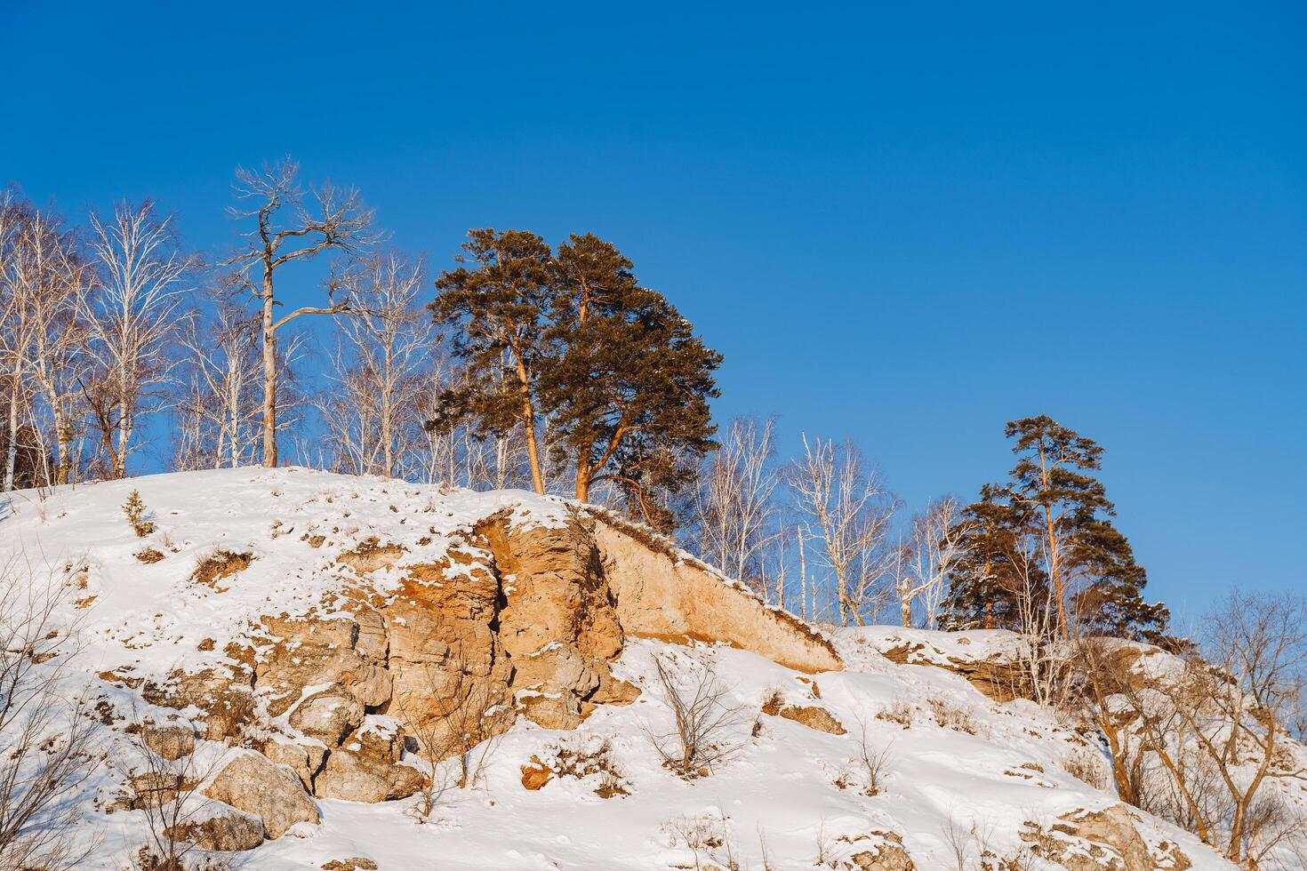 oranje rots onder de sneeuw tegen de blauw lucht. winter in Rusland, Basjkortostan, zuidelijk uralen, ufa. foto