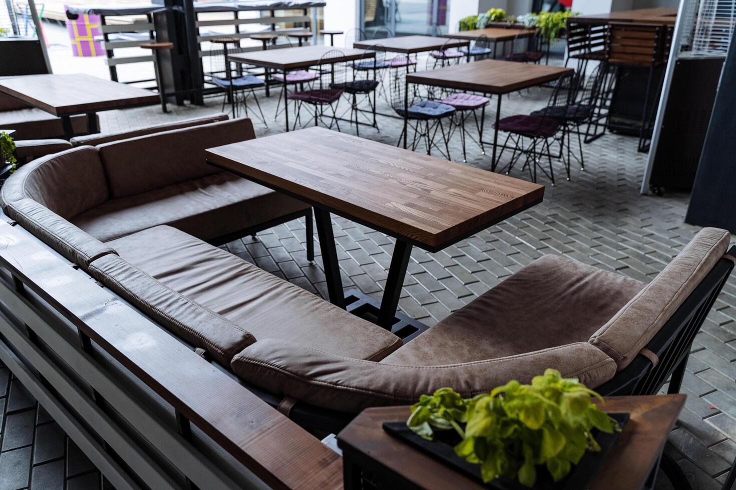 zomer cafe leeg tafel Nee gasten, lounge Oppervlakte voor restaurant bezoekers Aan de straat, interieur van de bar, zacht sofa voor zitten. zolder stijl. foto