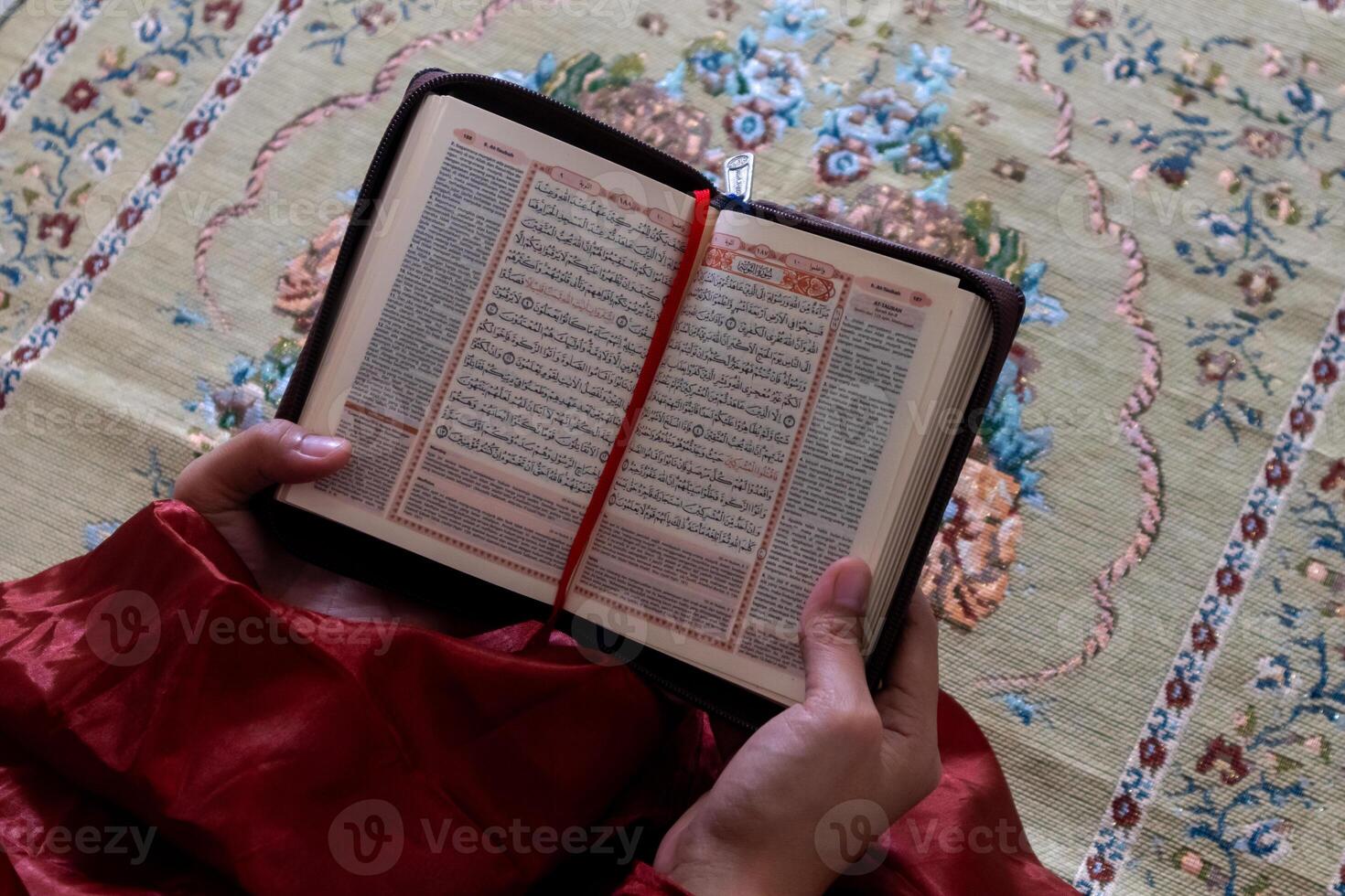 hand- van een moslim vrouw Holding de koran met Indonesisch vertaling foto