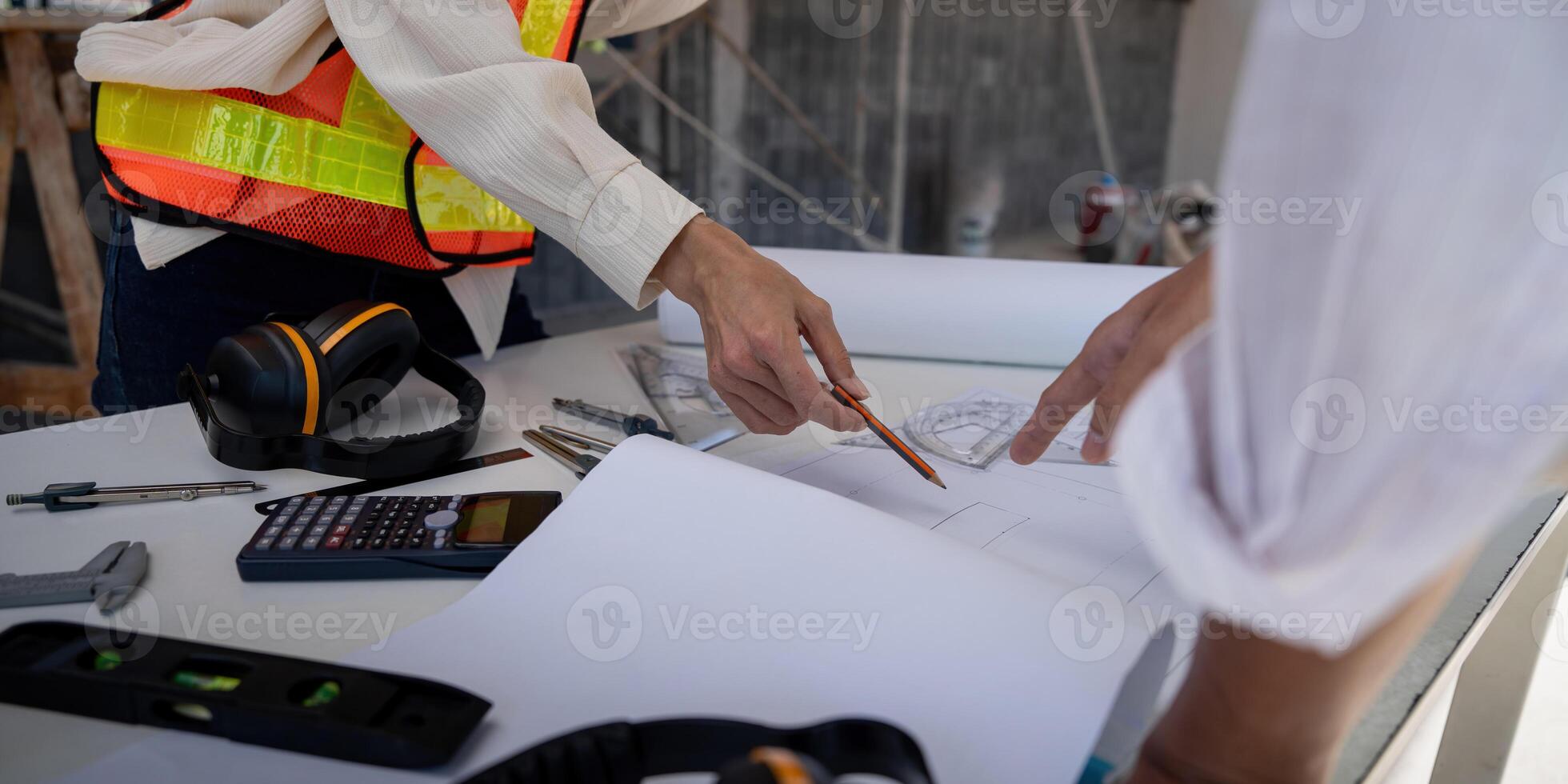 bouw concept van ingenieur of architect vergadering voor project werken met partner en bouwkunde gereedschap Aan gebouw en blauwdruk in werken plaats foto