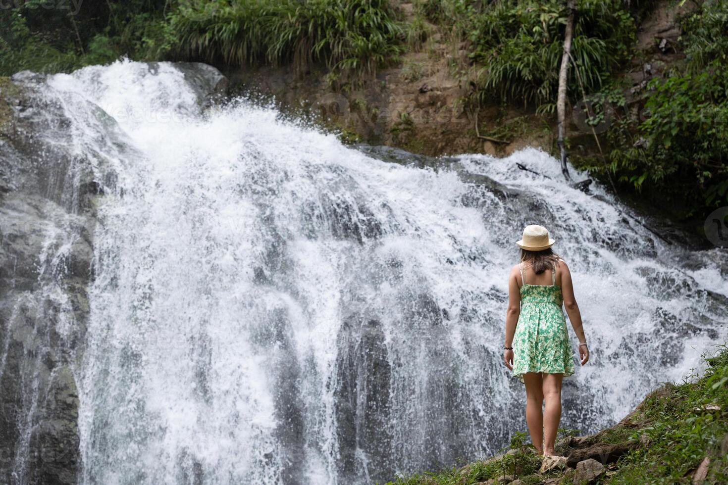 vrouw reiziger overweegt een waterval in de Peruaanse oerwoud. foto