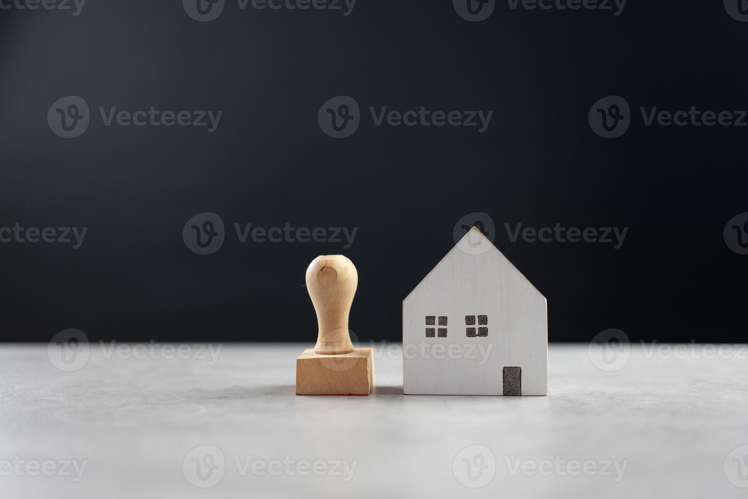 rubber postzegel en model- huis Aan tafel met zwart achtergrond foto