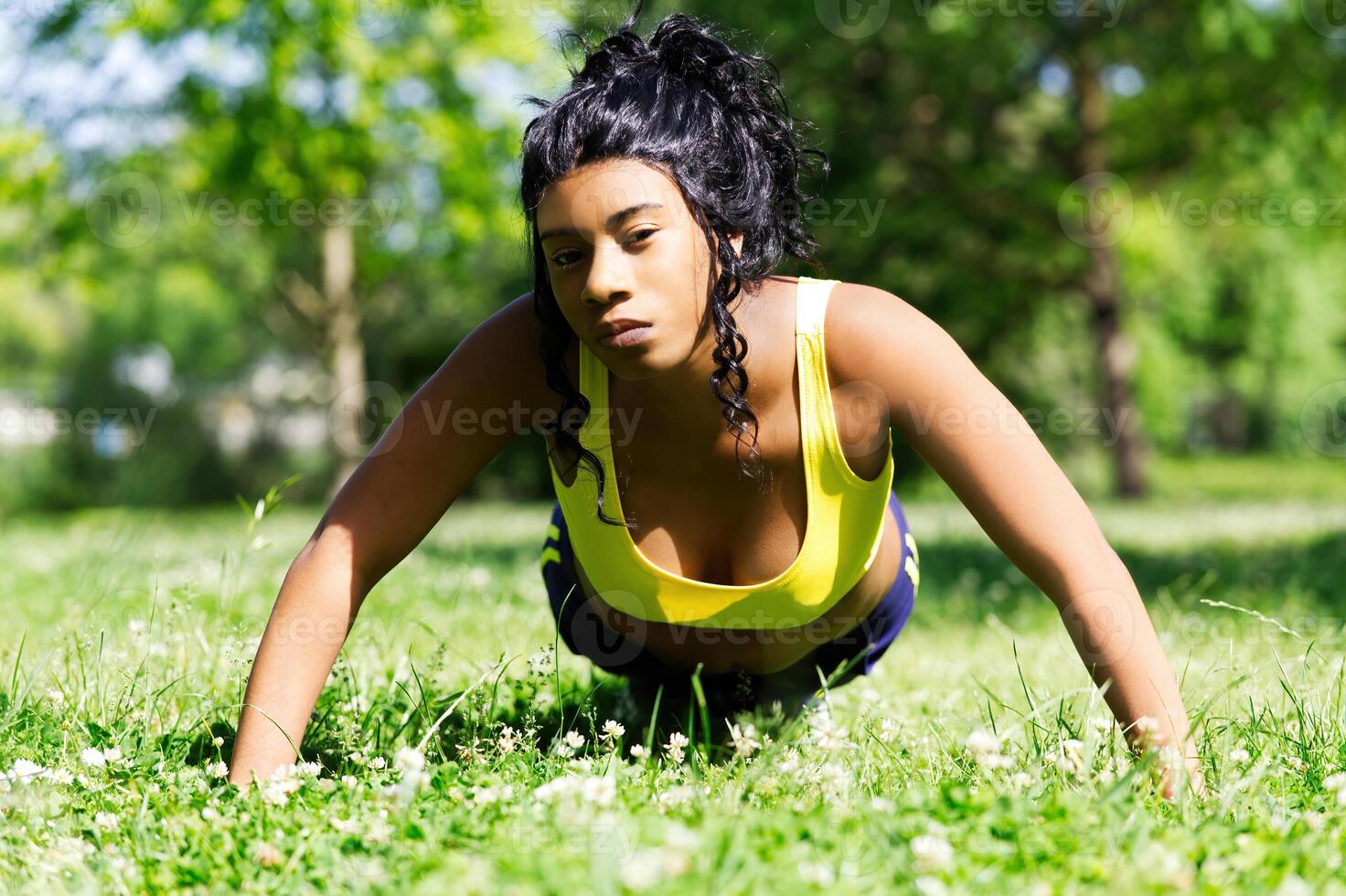 jong Afrikaanse Amerikaans vrouw aan het doen push-up buitenshuis Bij park foto