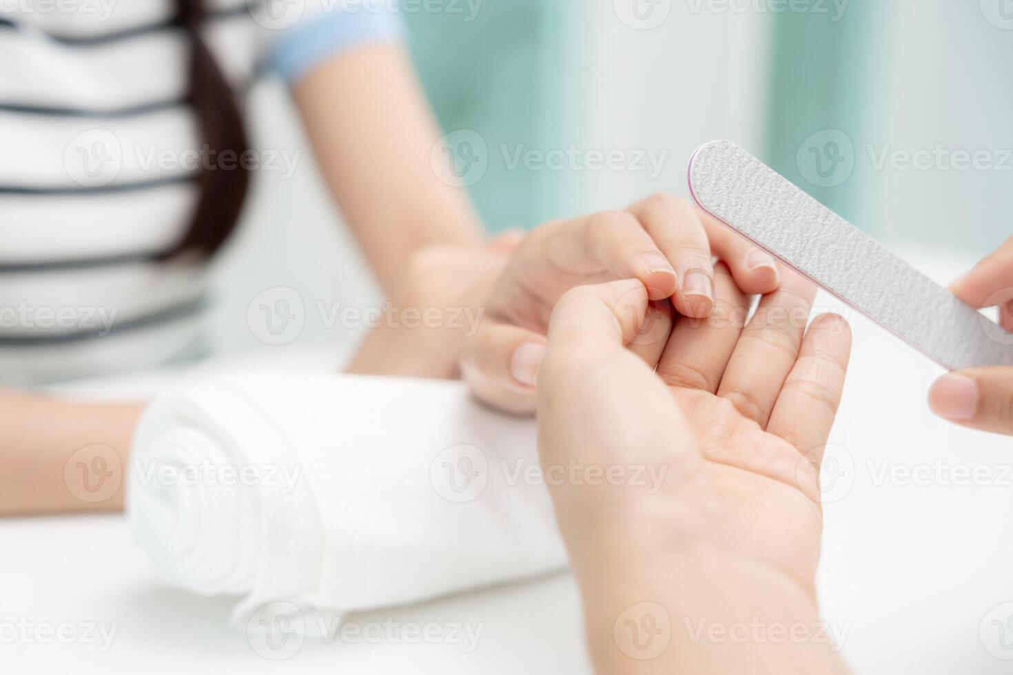 vrouw te ontvangen zorg onderhoud door professioneel schoonheidsspecialist manicure Bij spa centrum. nagel schoonheid salon gebruik nagel het dossier voor beglazing behandeling. manicure maken nagel klant naar mooi. lichaam zorg spa behandeling foto