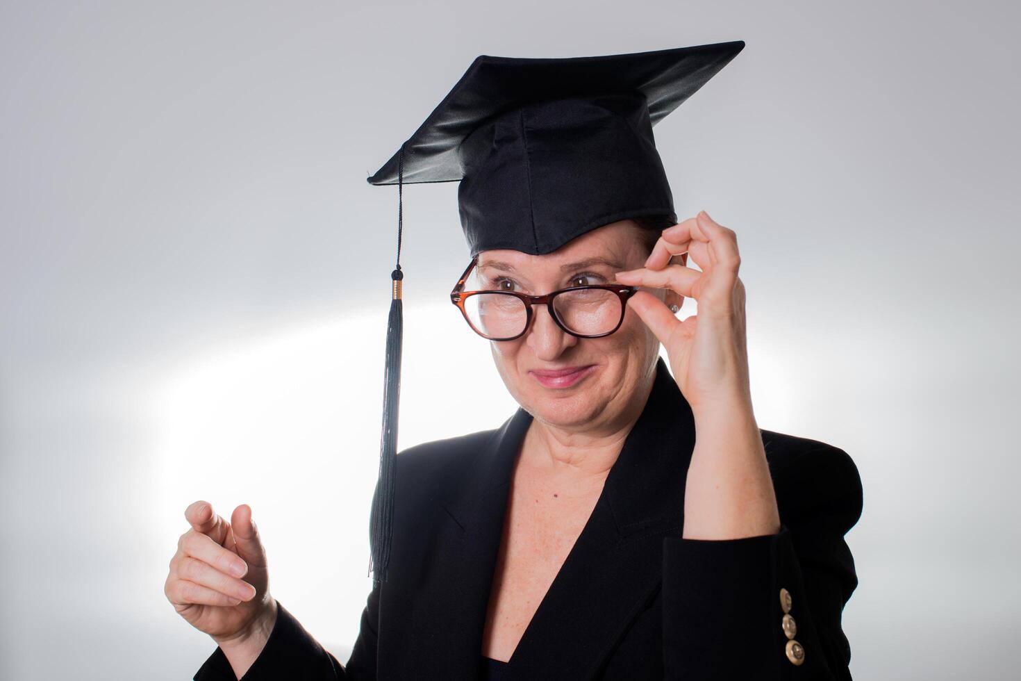 volwassen vrouw met diploma uitreiking pet op zoek over- haar bril foto