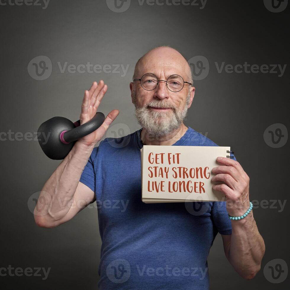 krijgen fit, blijven krachtig, leven langer - motiverende Notitie gehouden door een senior Mens oefenen met een kettlebell foto