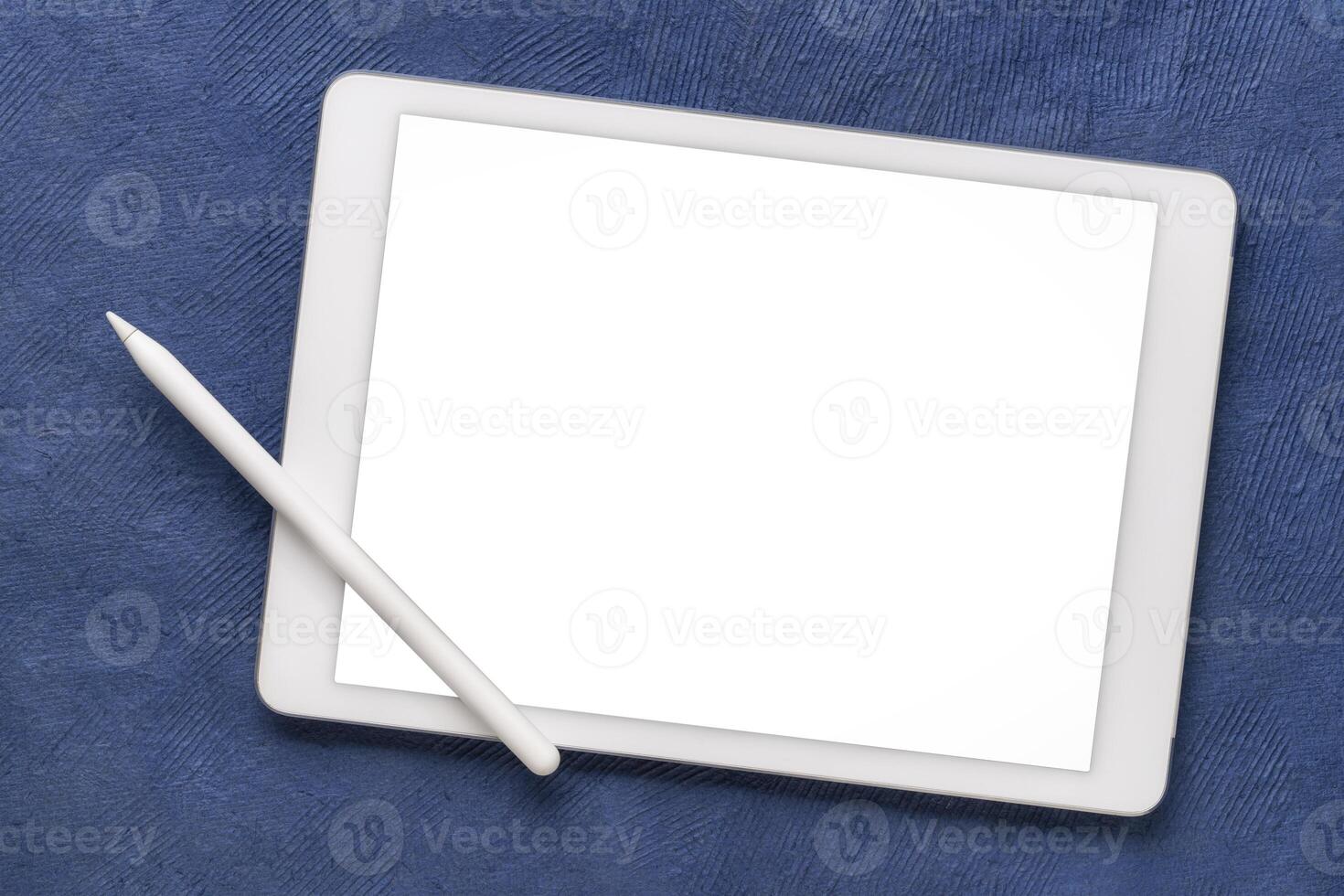 mockup van digitaal tablet met elektronisch potlood en een blanco geïsoleerd scherm, knipsel pad inbegrepen, tegen een blauw getextureerde kunst papier foto