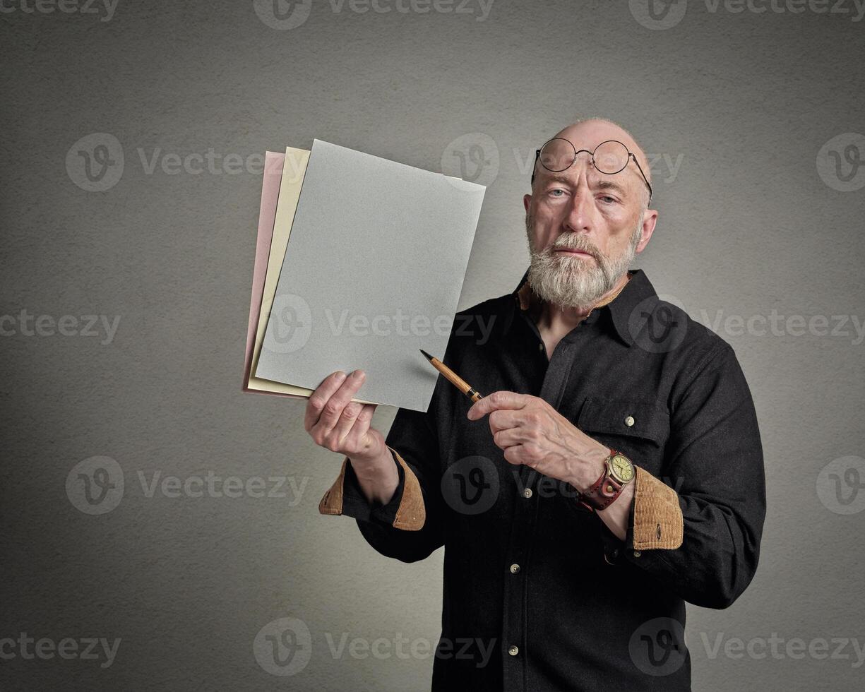 senior Mens is Holding een blanco vel van papier en een pen, presentatie concept foto