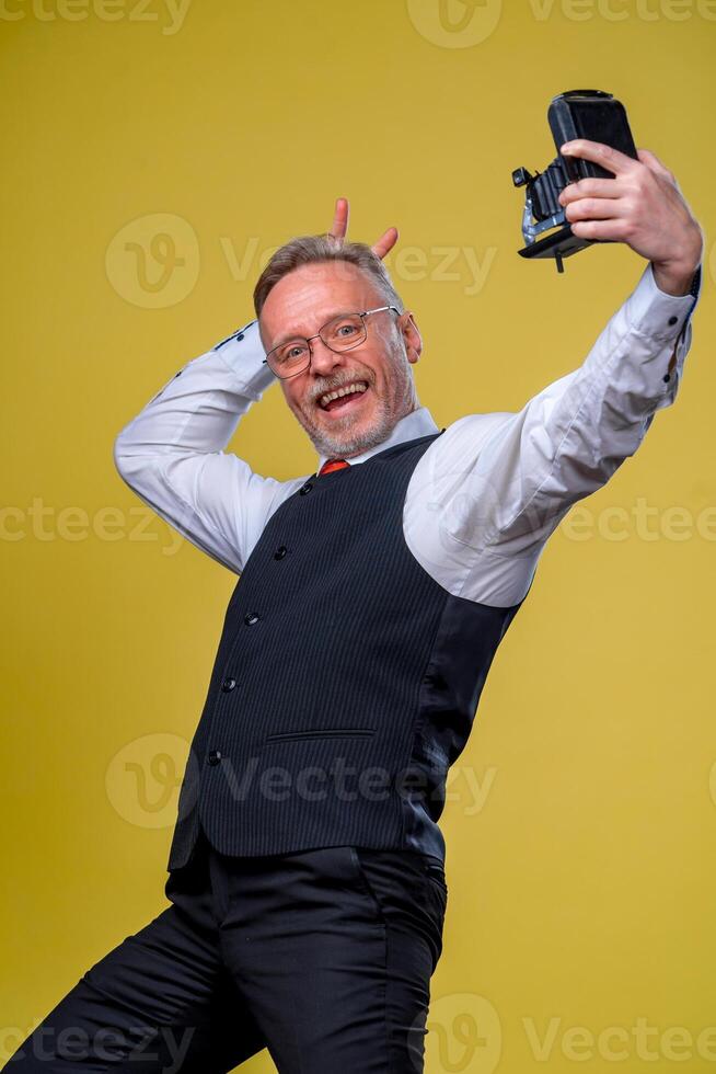 een schattig, gebaard Mens met bril gebouwd grappig gezicht en looks in de camera aan het doen selfie. dichtbij omhoog. foto