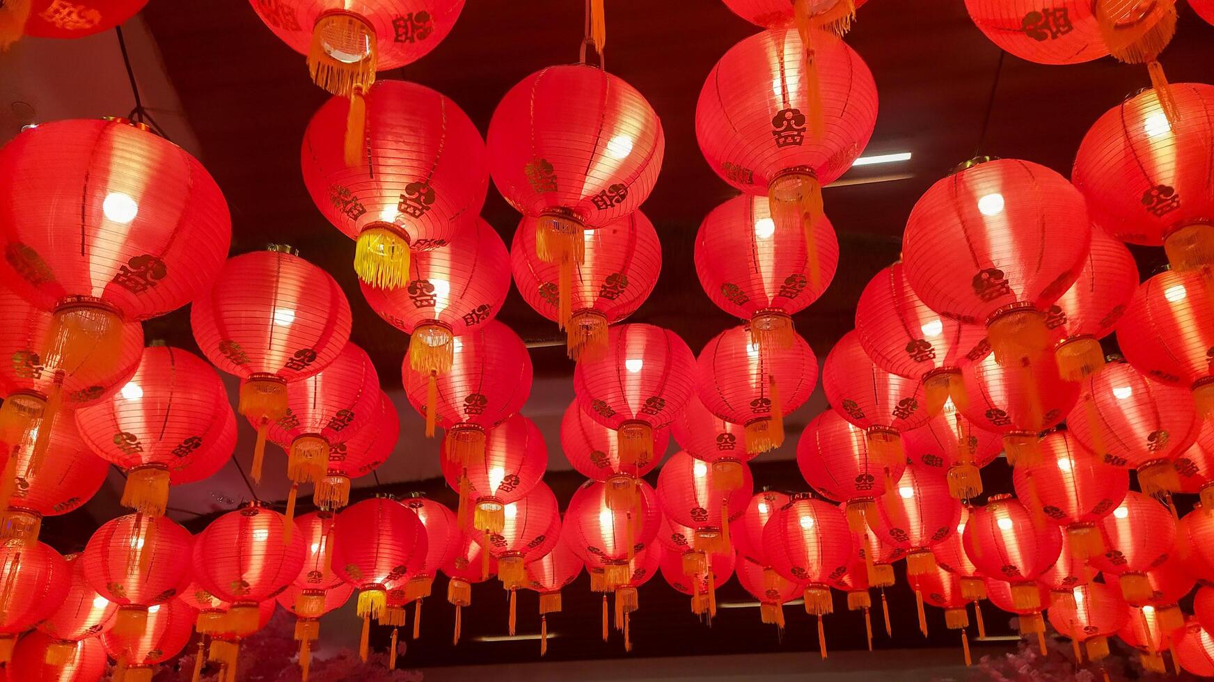 rood lantaarns zijn netjes bekleed omhoog Aan de dak vieren Chinese nieuw jaar foto