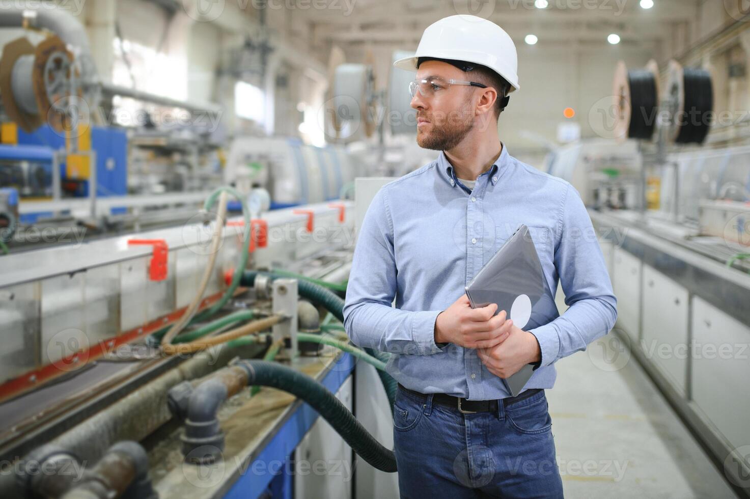 een jong mannetje ingenieur inspecteert de productie van plastic venster kaders foto