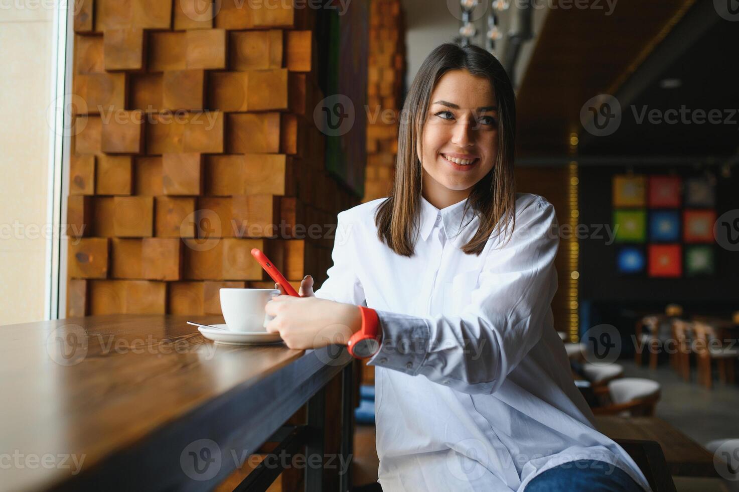 portret van mooi meisje met haar mobiele telefoon in café. foto