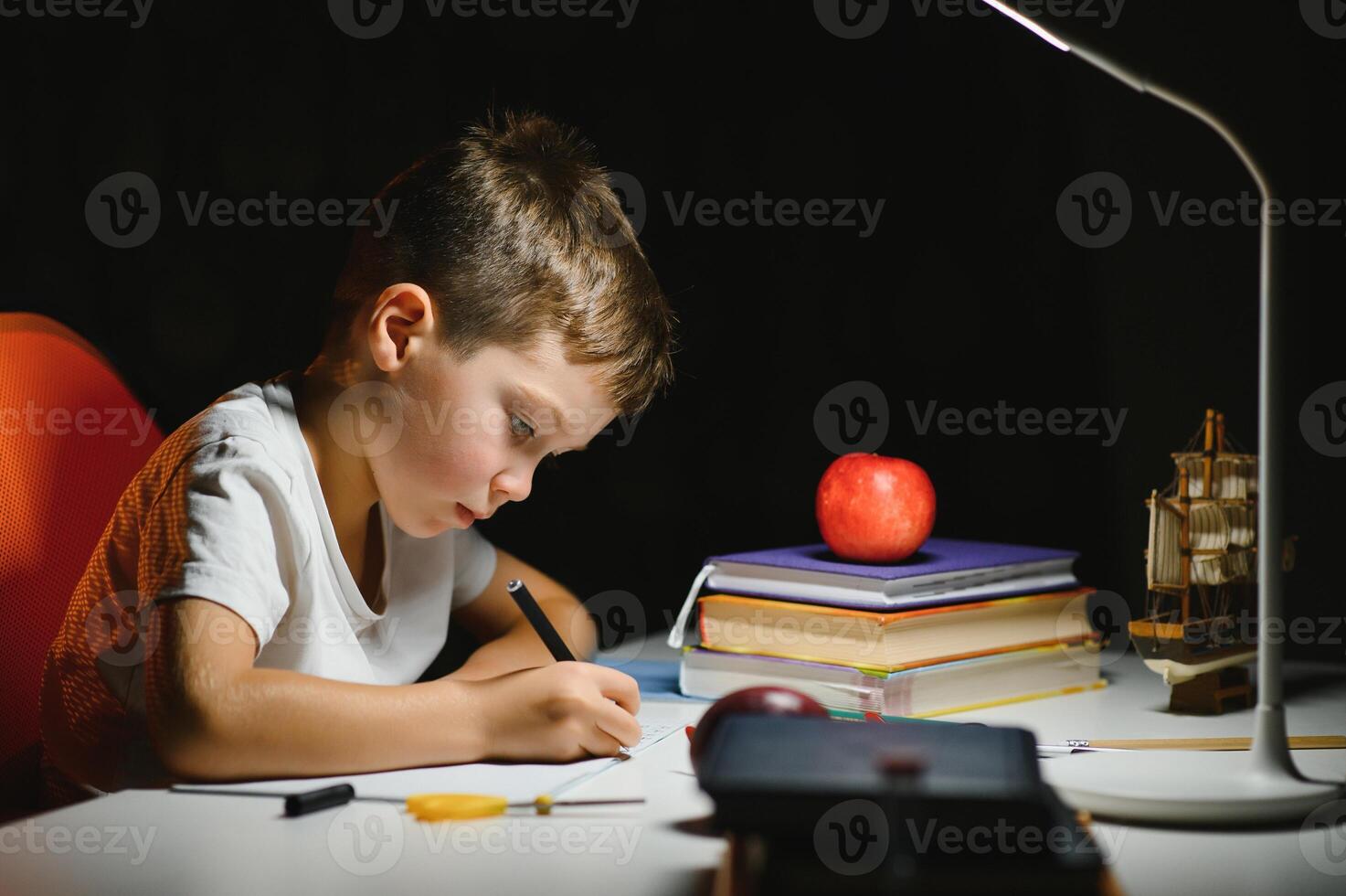 weinig jongen schilderij in een donker kamer laat in de avond foto