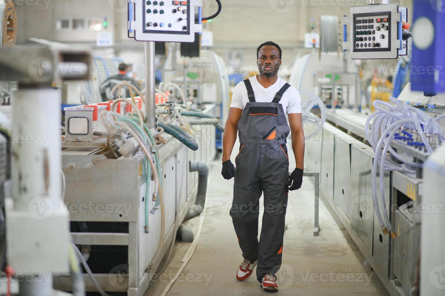 industrieel arbeider binnenshuis in fabriek. jong technicus met oranje moeilijk hoed foto