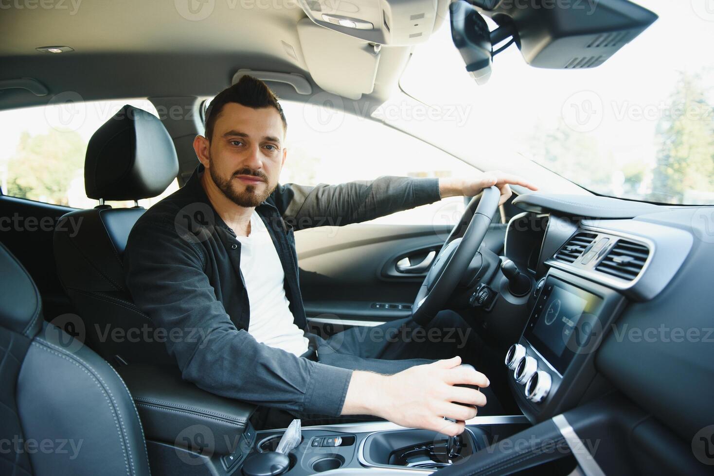 test rit voor auto. aangenaam dolblij knap jongen Holding stuurinrichting wiel en het rijden zijn auto terwijl uitdrukken blijdschap foto